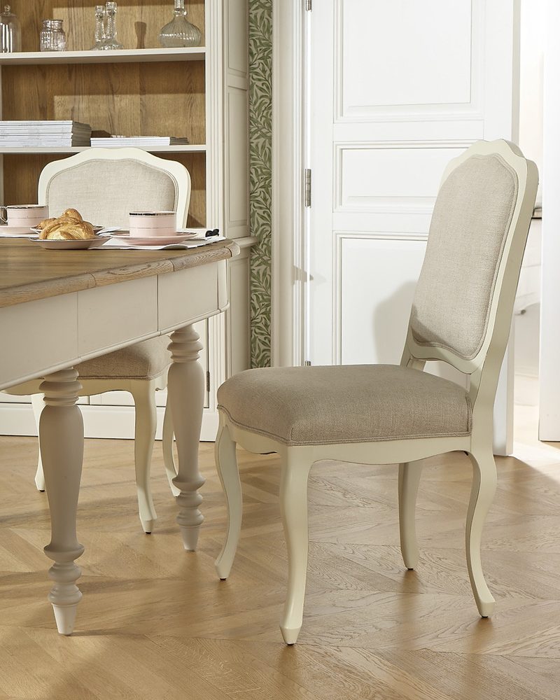 Chaise de salle à manger crème près d'une table, dans une pièce lumineuse